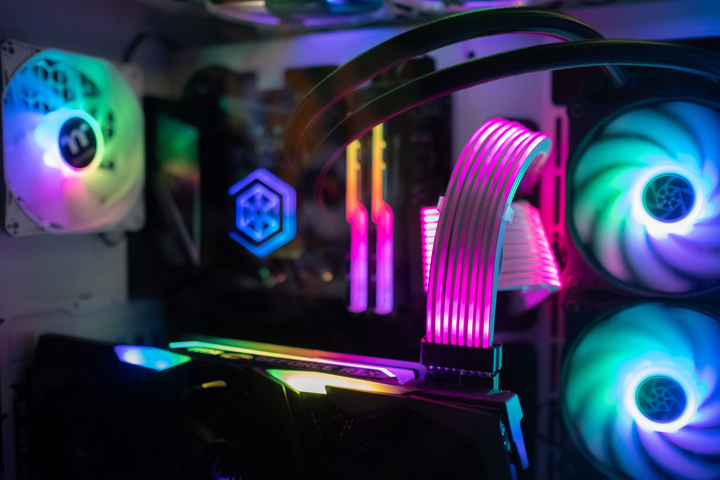 Interior de una PC con memoria, ventiladores y cables RGB
